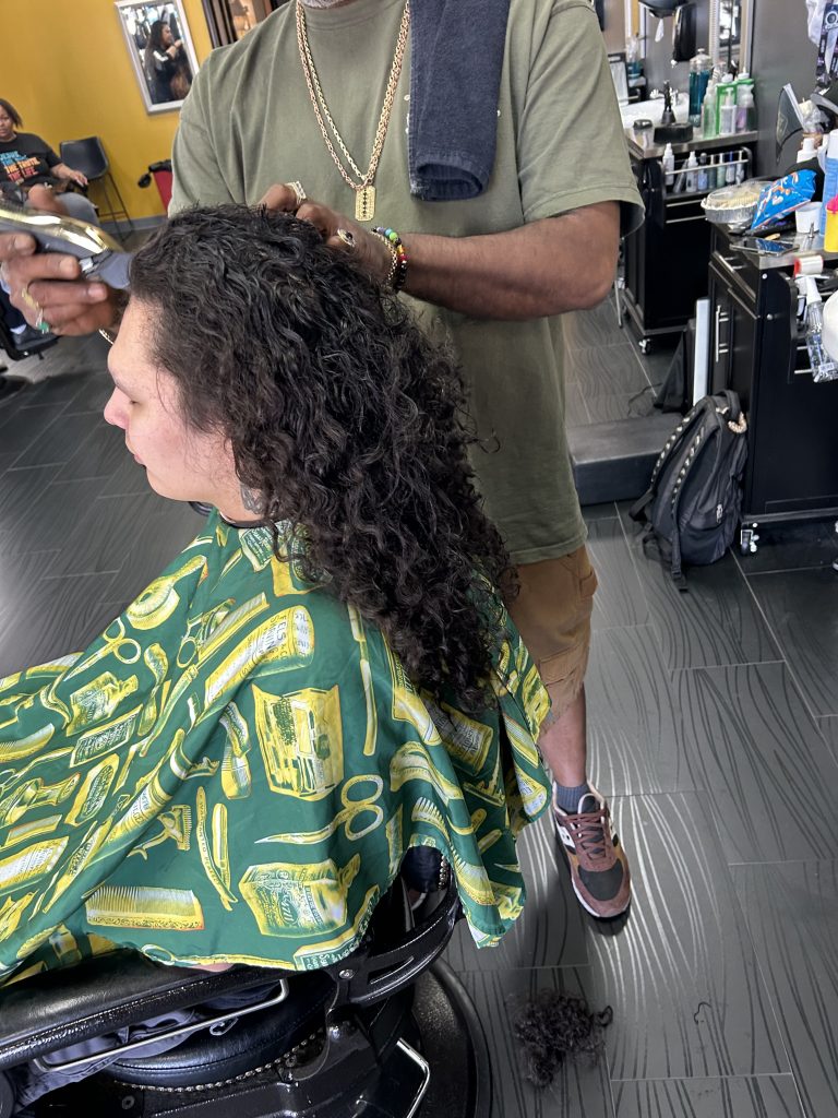 Man getting his long hair cut